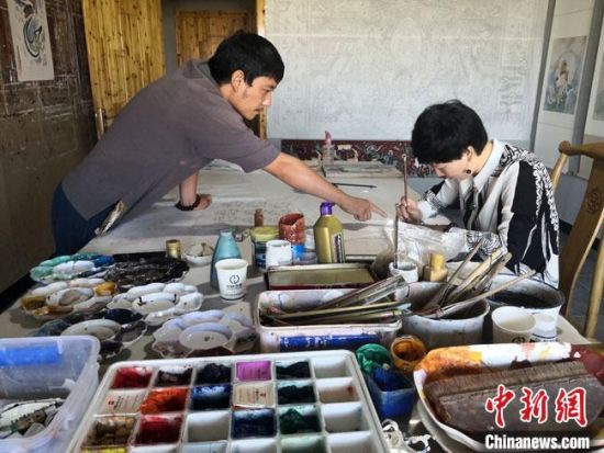 圖為2020年8月下旬，敦煌“80后”畫家張杰龍(左)在為云南麗江“學生”莫北講解敦煌壁畫的繪畫技巧?！●T志軍 攝