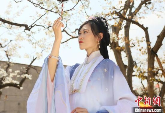 圖為蘭州青年身穿漢服在百年梨園賞景?！「哒?攝