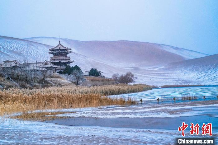 2021年11月28日，雪落鳴沙山月牙泉景區?！⊥醣筱y 攝