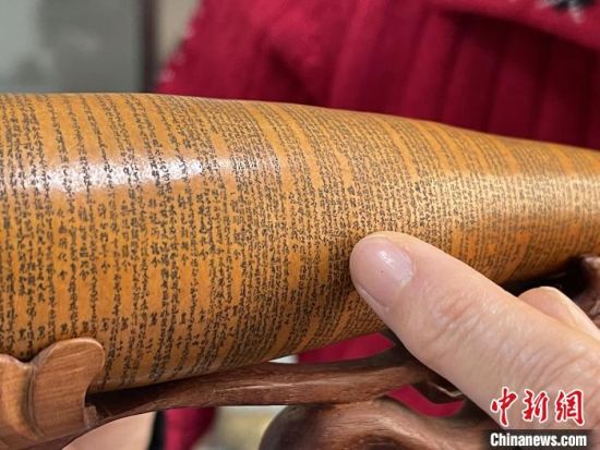 圖為長約二十公分的長條葫蘆雕刻佛教經(jīng)文作品。 張婧 攝 圖為長約二十公分的長條葫蘆雕刻佛教經(jīng)文作品。 張婧 攝