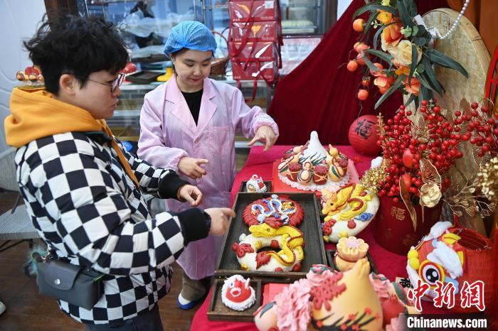 1月25日,隨著春節臨近,蘭州一花饃店“龍”元素花饃熱銷。圖為工作人員向顧客推薦“龍”元素花饃。九美旦增 攝</p><p> 1月25日,隨著春節臨近,蘭州一花饃店“龍”元素花饃熱銷。圖為工作人員向顧客推薦“龍”元素花饃。九美旦增 攝</p><p>