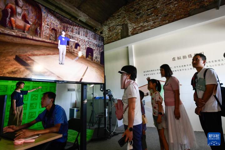 7月22日,游客體驗“尋境敦煌——數字敦煌沉浸展”后,在虛擬演播廳拍攝一段真人與洞窟虛擬場景交互的視頻。新華社記者 郎兵兵 攝</p>
<p> 7月22日,游客體驗“尋境敦煌——數字敦煌沉浸展”后,在虛擬演播廳拍攝一段真人與洞窟虛擬場景交互的視頻。新華社記者 郎兵兵 攝</p>
<p>