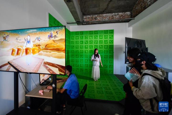 7月22日,游客體驗“尋境敦煌——數字敦煌沉浸展”后,在虛擬演播廳拍攝一段真人與洞窟虛擬場景交互的視頻。新華社記者 郎兵兵 攝</p>
<p> 7月22日,游客體驗“尋境敦煌——數字敦煌沉浸展”后,在虛擬演播廳拍攝一段真人與洞窟虛擬場景交互的視頻。新華社記者 郎兵兵 攝</p>
<p>